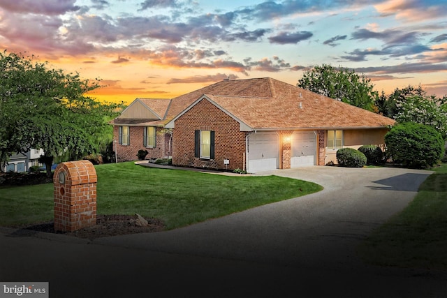 single story home featuring a yard, brick siding, concrete driveway, and a garage