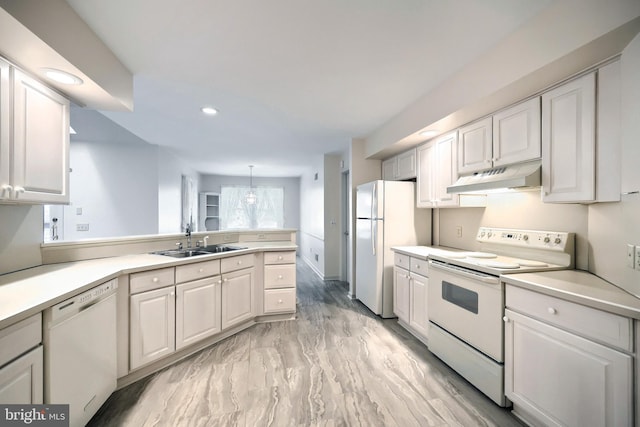 kitchen with a sink, light countertops, a peninsula, under cabinet range hood, and white appliances
