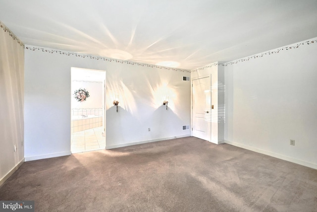 carpeted empty room featuring baseboards and visible vents