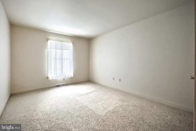 empty room featuring visible vents, carpet, and baseboards