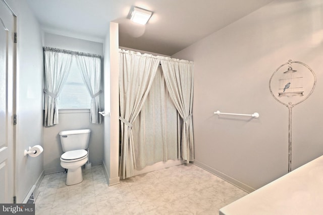 full bathroom featuring baseboards, tile patterned floors, and toilet