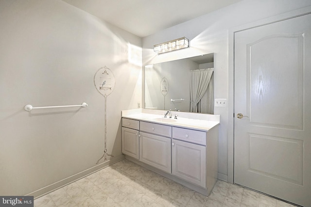 bathroom with baseboards, marble finish floor, and vanity