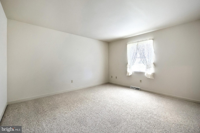 carpeted empty room with baseboards and visible vents