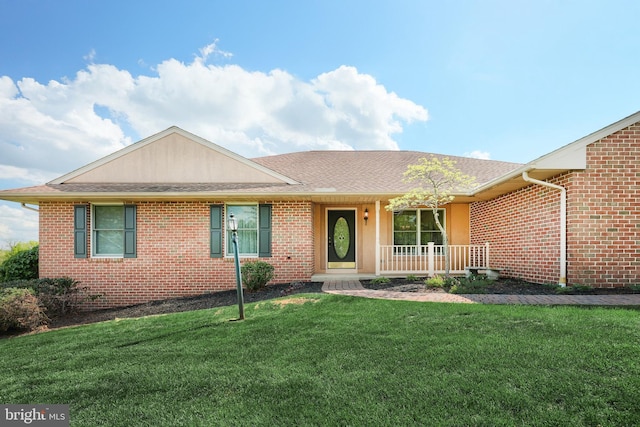 ranch-style house with a porch, brick siding, a shingled roof, and a front lawn