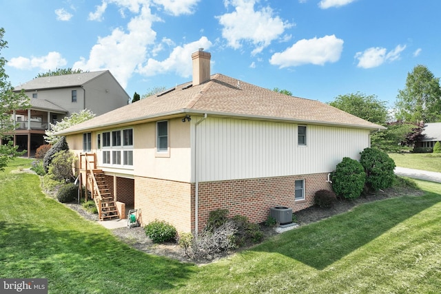 view of property exterior with a chimney, a lawn, stairway, brick siding, and central AC