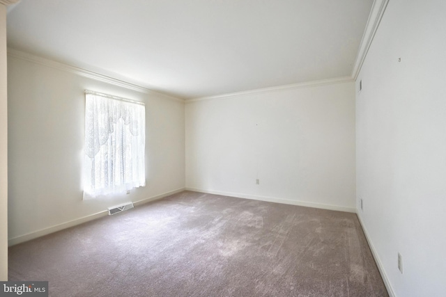 carpeted spare room featuring baseboards, ornamental molding, and visible vents