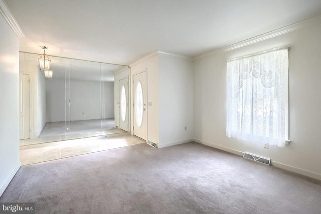 foyer entrance featuring crown molding, baseboards, visible vents, and carpet floors