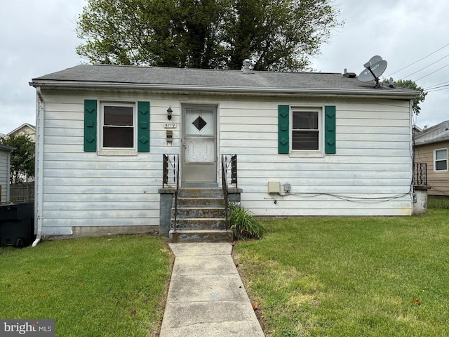 view of front of home featuring entry steps and a front lawn