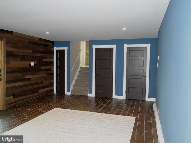 foyer entrance with stairway, baseboards, wood tiled floor, and recessed lighting