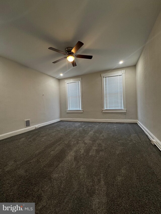 2609 W Fayette St, Baltimore, MD 21223 - spare room featuring ceiling fan, baseboards, and dark colored carpet
