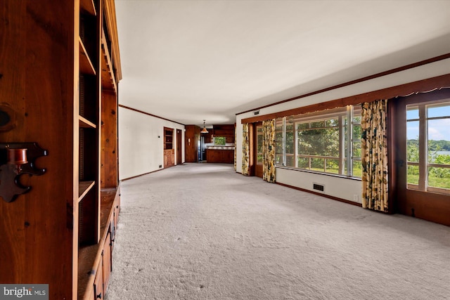 unfurnished living room with carpet, baseboards, and ornamental molding