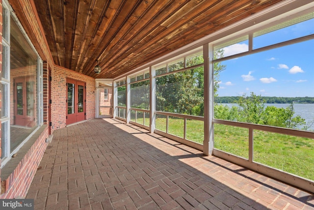 unfurnished sunroom with a water view