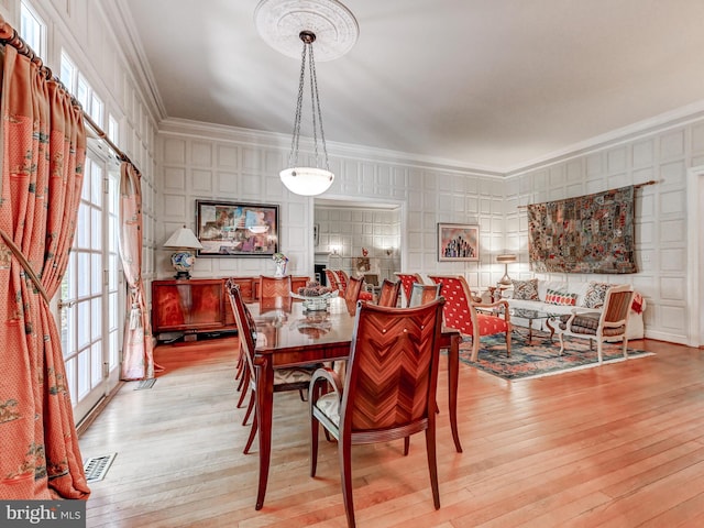 26 Bellchase Ct Unit B, Pikesville, MD 21208 - dining space with ornamental molding, a decorative wall, and light wood-style flooring