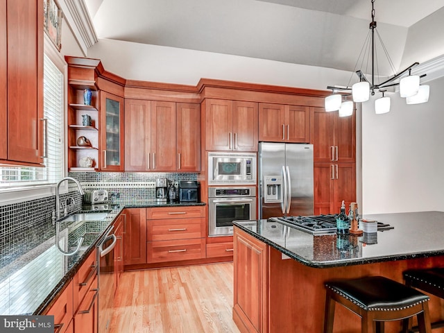 26 Bellchase Ct Unit B, Pikesville, MD 21208 - kitchen featuring stainless steel appliances, a sink, brown cabinets, light wood finished floors, and decorative backsplash