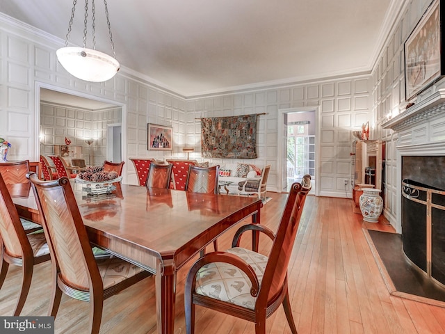 26 Bellchase Ct Unit B, Pikesville, MD 21208 - dining area featuring crown molding, a fireplace, wood-type flooring, and a decorative wall