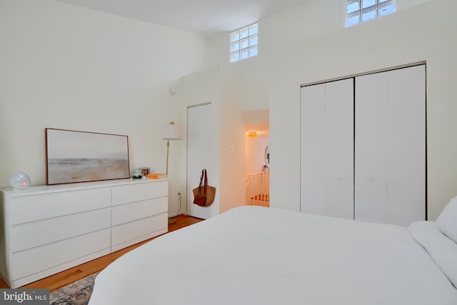 bedroom featuring a high ceiling, wood finished floors, and a closet
