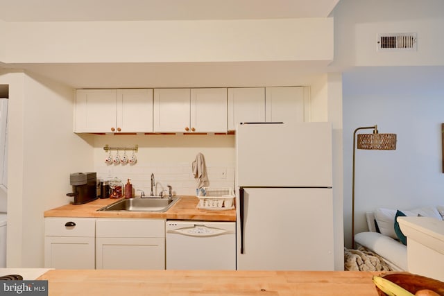 kitchen with white appliances, a sink, wood counters, decorative backsplash, and white cabinets