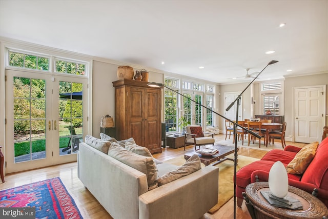 living room featuring light wood finished floors, ornamental molding, and recessed lighting