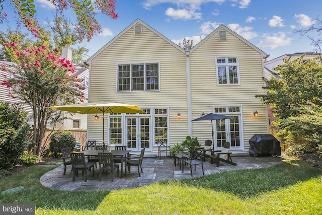 rear view of property with a patio area, french doors, a lawn, and fence