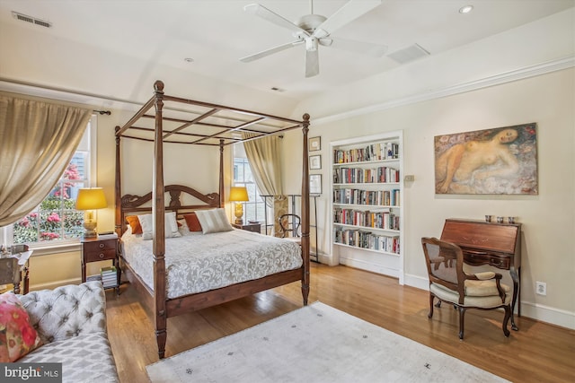 bedroom featuring multiple windows, visible vents, wood finished floors, and baseboards