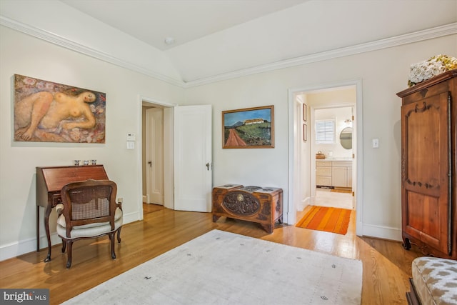 living area with light wood finished floors, baseboards, and ornamental molding