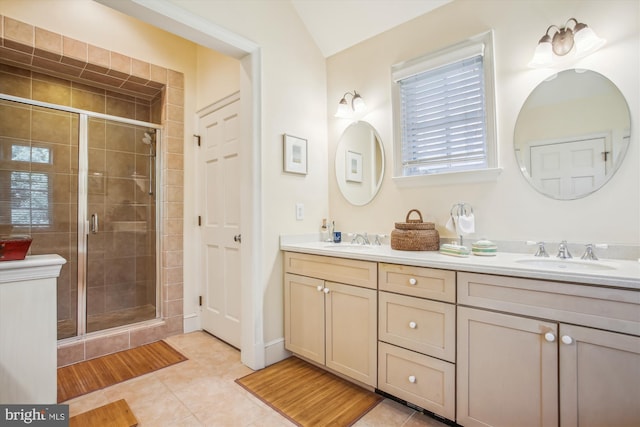 full bathroom featuring double vanity, tile patterned floors, a shower stall, and a sink
