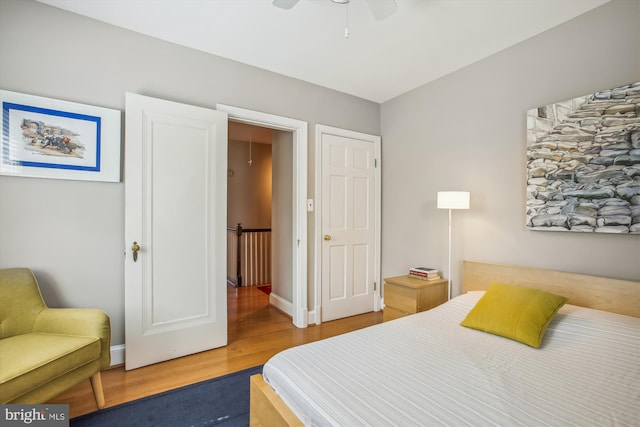 bedroom with ceiling fan, baseboards, and wood finished floors