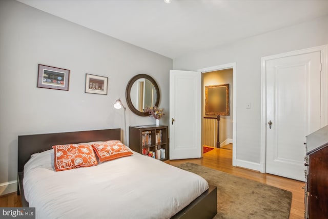 bedroom with baseboards and wood finished floors