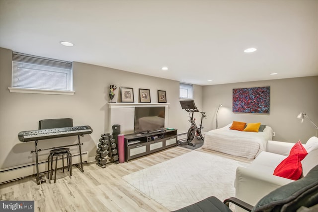bedroom with a baseboard heating unit, recessed lighting, and wood finished floors