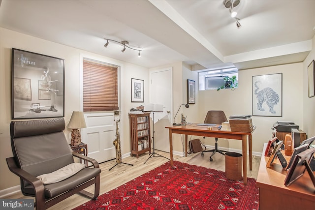office with baseboards, wood finished floors, and track lighting