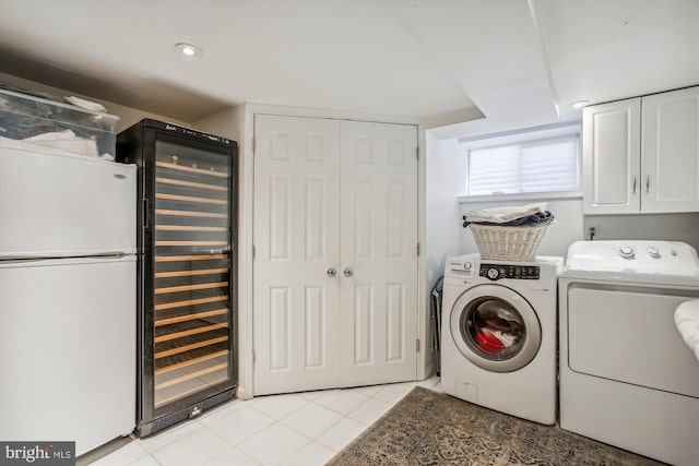 washroom featuring beverage cooler, light tile patterned floors, cabinet space, separate washer and dryer, and recessed lighting
