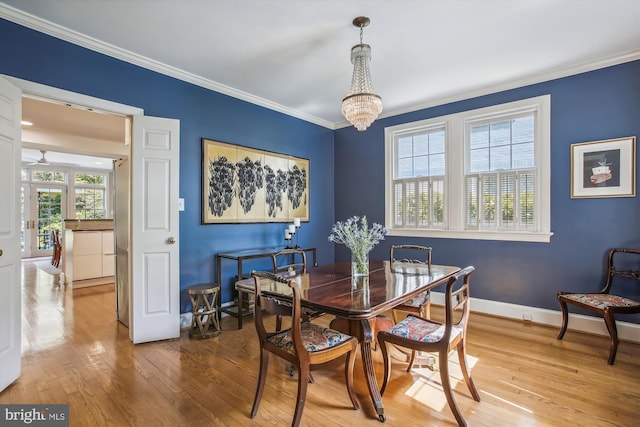 dining space with baseboards, ornamental molding, an inviting chandelier, and wood-type flooring