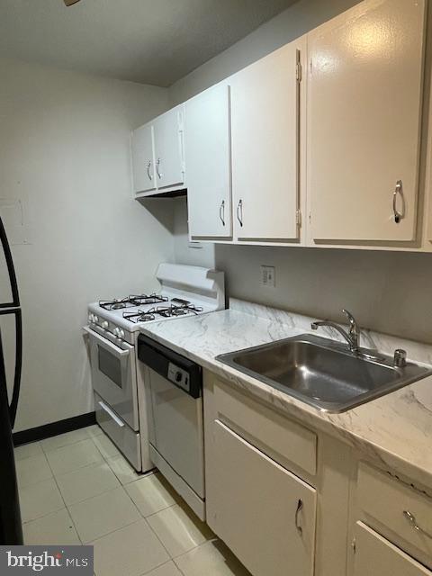 1301 20th St NW Unit 316, Washington, DC 20036 - kitchen featuring white gas range, dishwasher, light countertops, and a sink