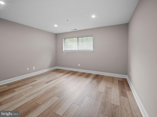 spare room with light wood-style floors, baseboards, and recessed lighting