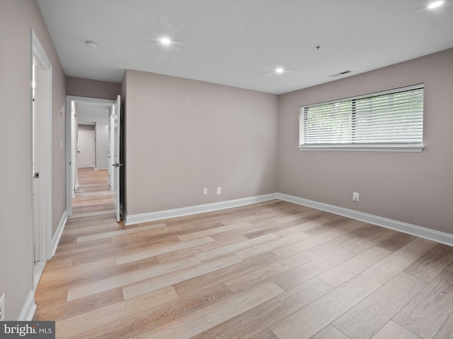 spare room featuring light wood-type flooring, recessed lighting, baseboards, and visible vents