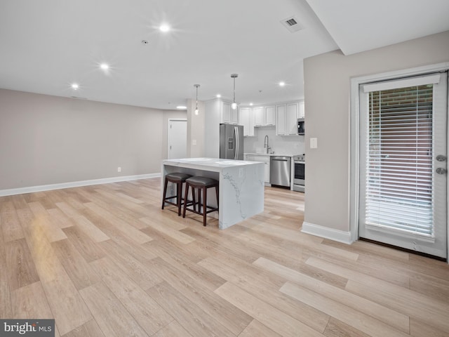 kitchen featuring a sink, stainless steel appliances, visible vents, light countertops, and recessed lighting