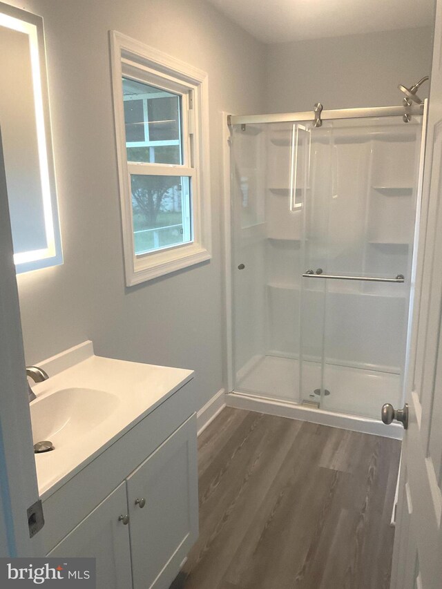 54 Bryan Dr, Rehoboth Beach, DE 19971 - full bath featuring a stall shower, vanity, baseboards, and wood finished floors