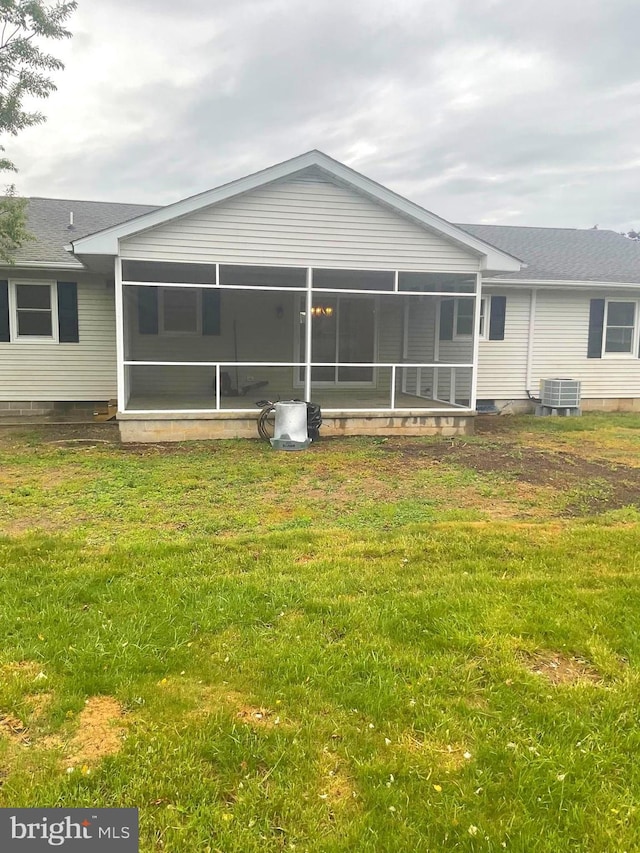 54 Bryan Dr, Rehoboth Beach, DE 19971 - back of property featuring a sunroom, a shingled roof, a lawn, and central AC