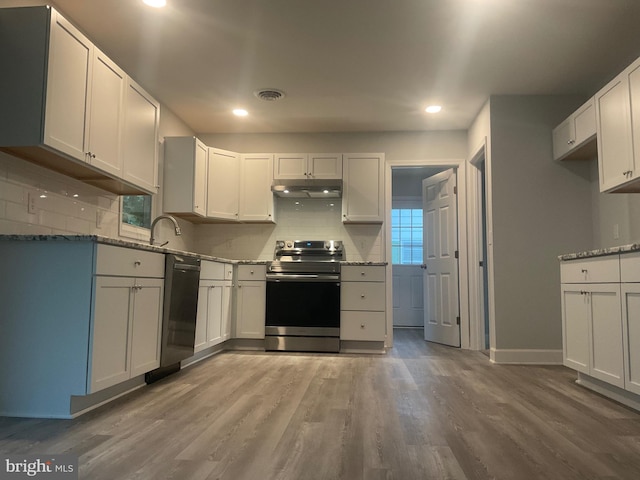 54 Bryan Dr, Rehoboth Beach, DE 19971 - kitchen with wood finished floors, dishwasher, under cabinet range hood, backsplash, and electric range