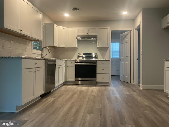 54 Bryan Dr, Rehoboth Beach, DE 19971 - kitchen featuring under cabinet range hood, stainless steel appliances, tasteful backsplash, and light stone countertops