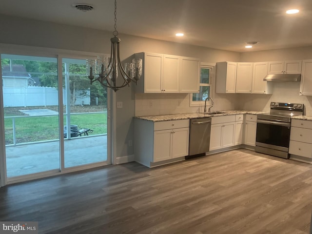 54 Bryan Dr, Rehoboth Beach, DE 19971 - kitchen featuring a notable chandelier, light stone countertops, under cabinet range hood, white cabinetry, and appliances with stainless steel finishes