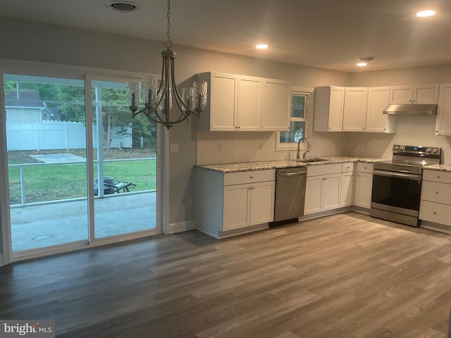 54 Bryan Dr, Rehoboth Beach, DE 19971 - kitchen with stainless steel appliances, under cabinet range hood, light stone countertops, white cabinets, and recessed lighting