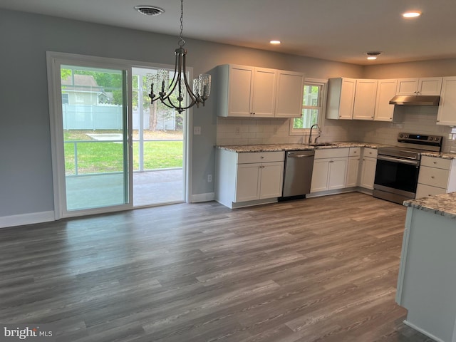 54 Bryan Dr, Rehoboth Beach, DE 19971 - kitchen with appliances with stainless steel finishes, a chandelier, under cabinet range hood, backsplash, and recessed lighting