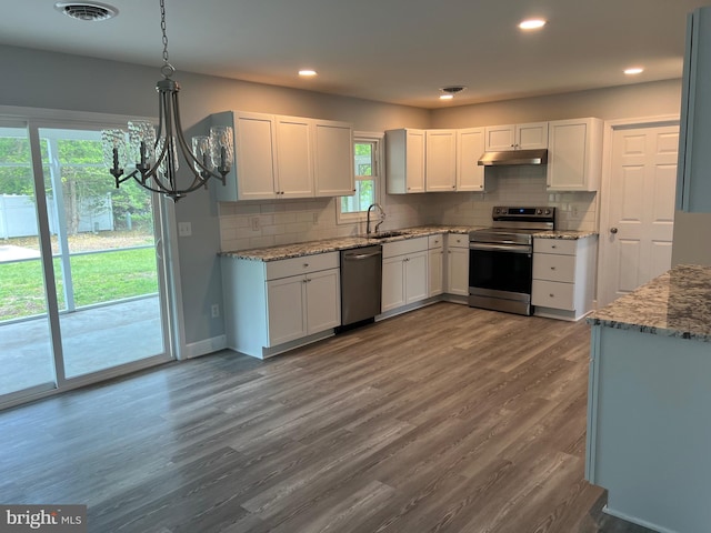 54 Bryan Dr, Rehoboth Beach, DE 19971 - kitchen with stainless steel appliances, under cabinet range hood, a sink, a chandelier, and decorative backsplash