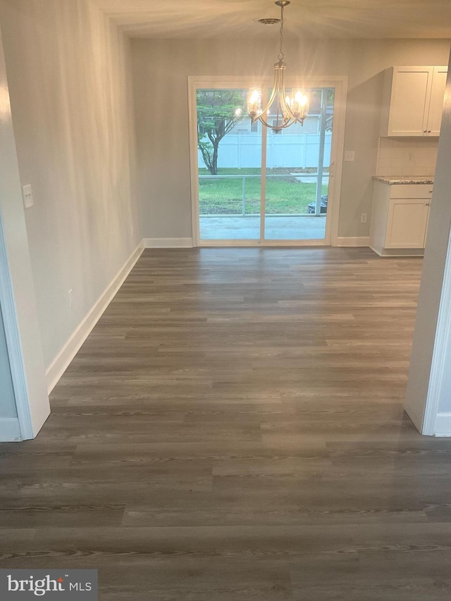 54 Bryan Dr, Rehoboth Beach, DE 19971 - unfurnished dining area featuring dark wood-style flooring, baseboards, and a notable chandelier