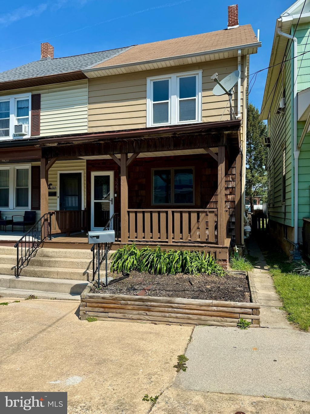 view of front of property featuring a porch, roof with shingles, a chimney, and cooling unit