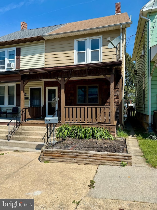 view of front of property featuring a porch, roof with shingles, a chimney, and cooling unit