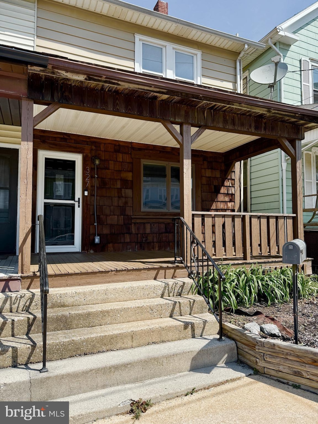 doorway to property with covered porch and a chimney