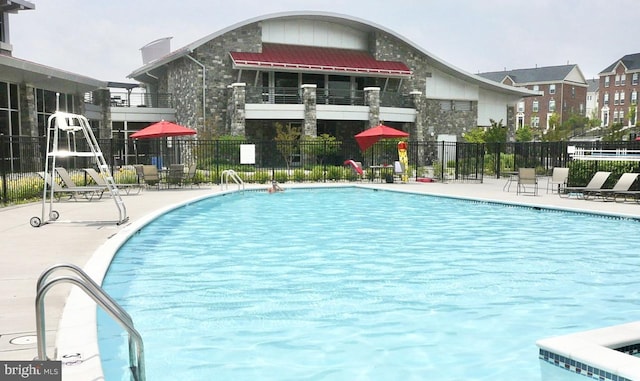 community pool with fence and a patio