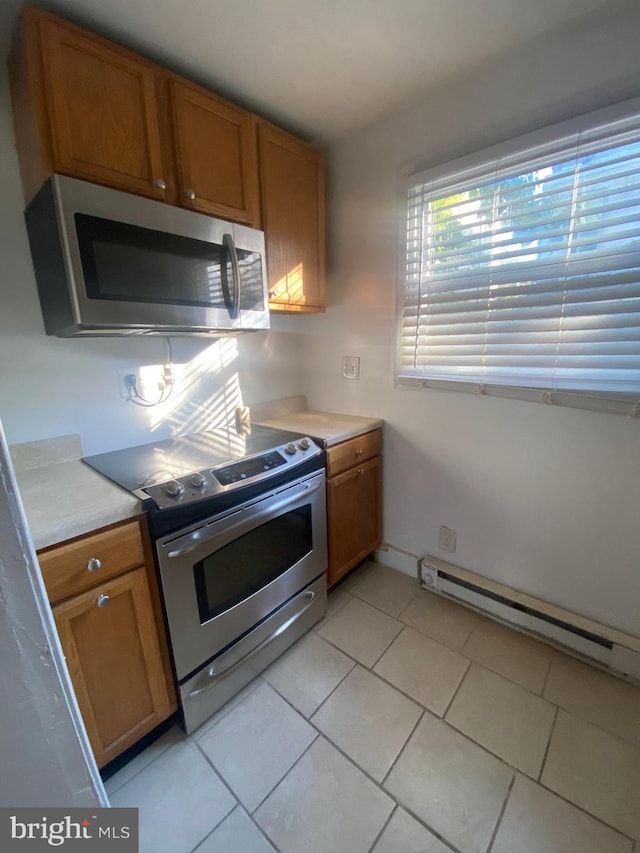 2718 W Sterner St, Philadelphia, PA 19132 - kitchen with brown cabinetry, light countertops, stainless steel appliances, and a baseboard heating unit